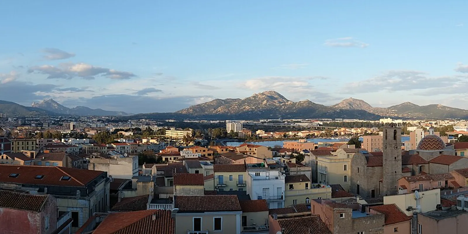 Tejados de Olbia y colinas cercanas bajo el cielo de la tarde